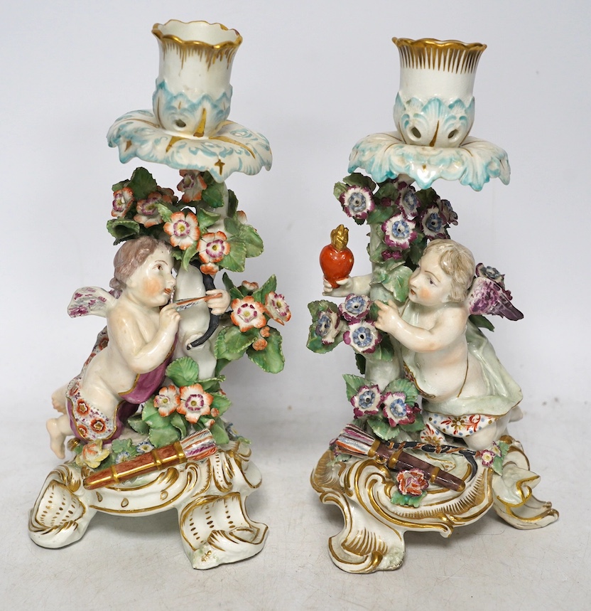 A pair of 19th century Derby porcelain candlesticks, with ‘winged cupid’ stems, 22cm. Condition - poor